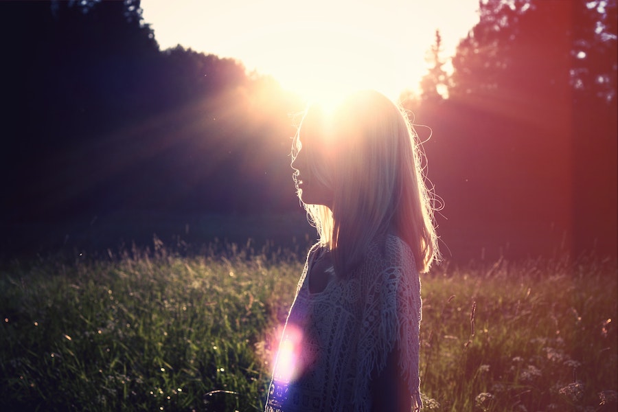 Peaceful image of a woman backlit by early morning sunshine