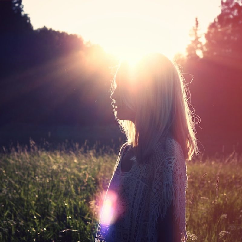 Peaceful image of a woman backlit by early morning sunshine